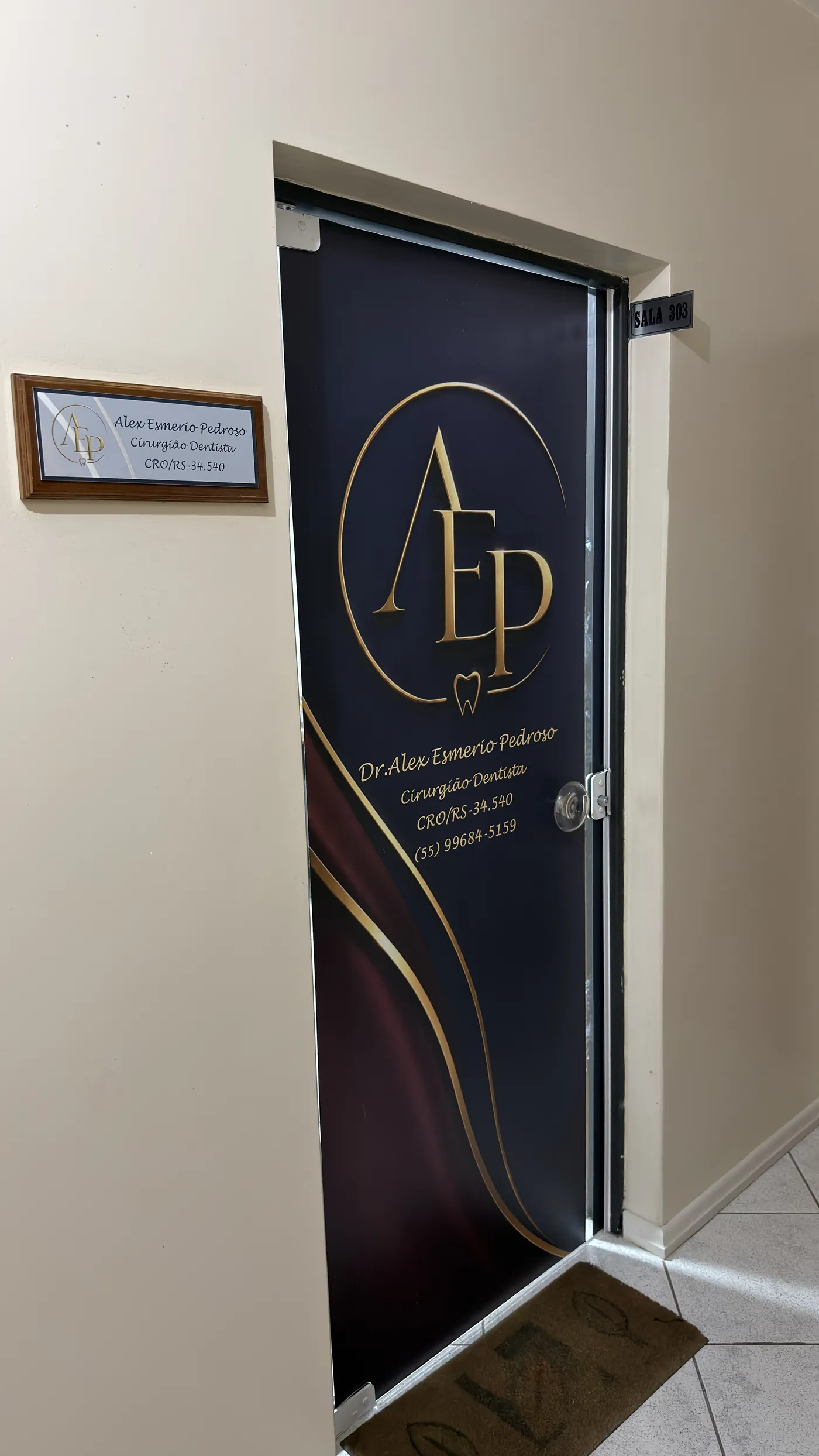 Porta do consultório com o monograma dourado AEP e a identificação do Dr. Alex Esmerio Pedroso, Cirurgião-Dentista